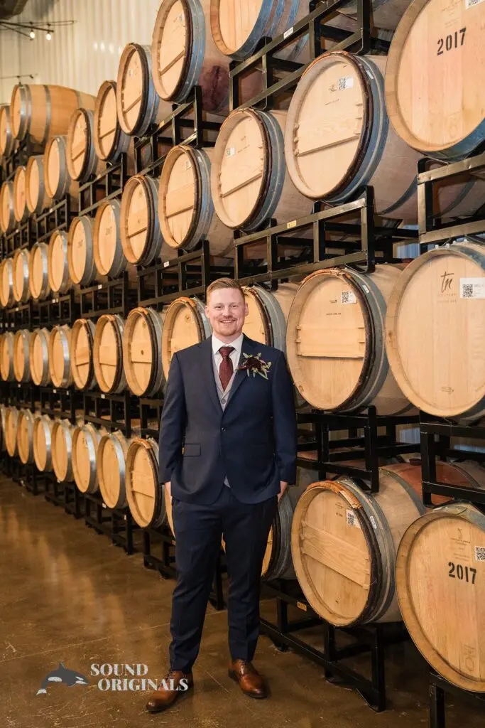 Handsome groom with big wine barrels at the background at Folino Estate Winery