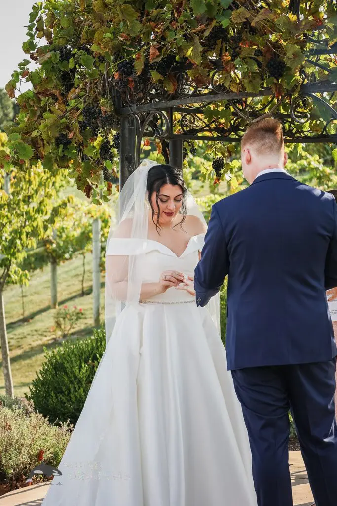 Bride putting the ring on the groom at Folino Estate Winery