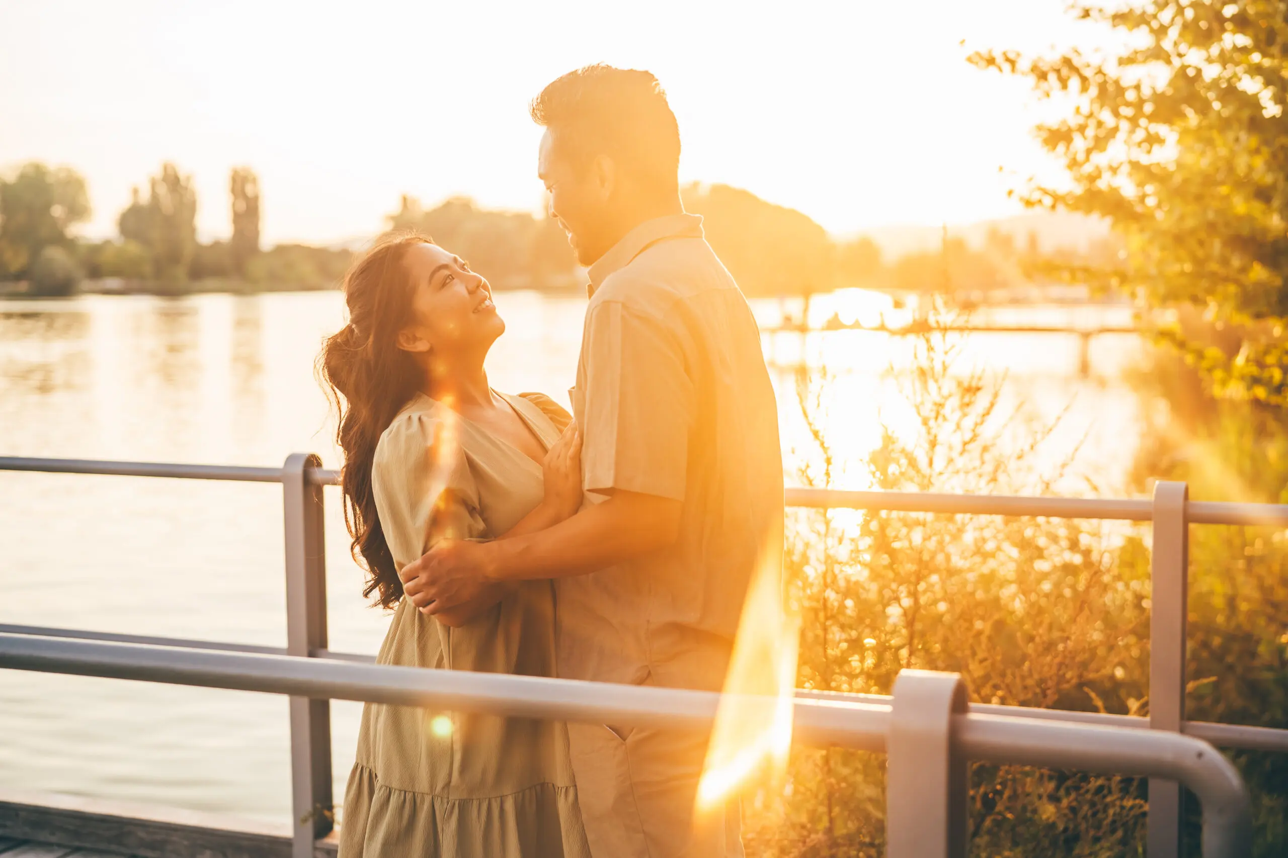 A candid photo of a couple laughing together in golden hour light, natural and joyful