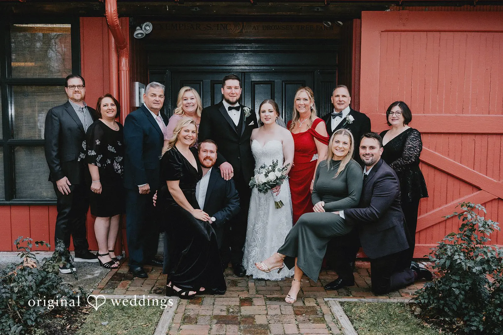 Stephanie + Zachary A portrait of the bride and groom with the family at Bishop Farmstead