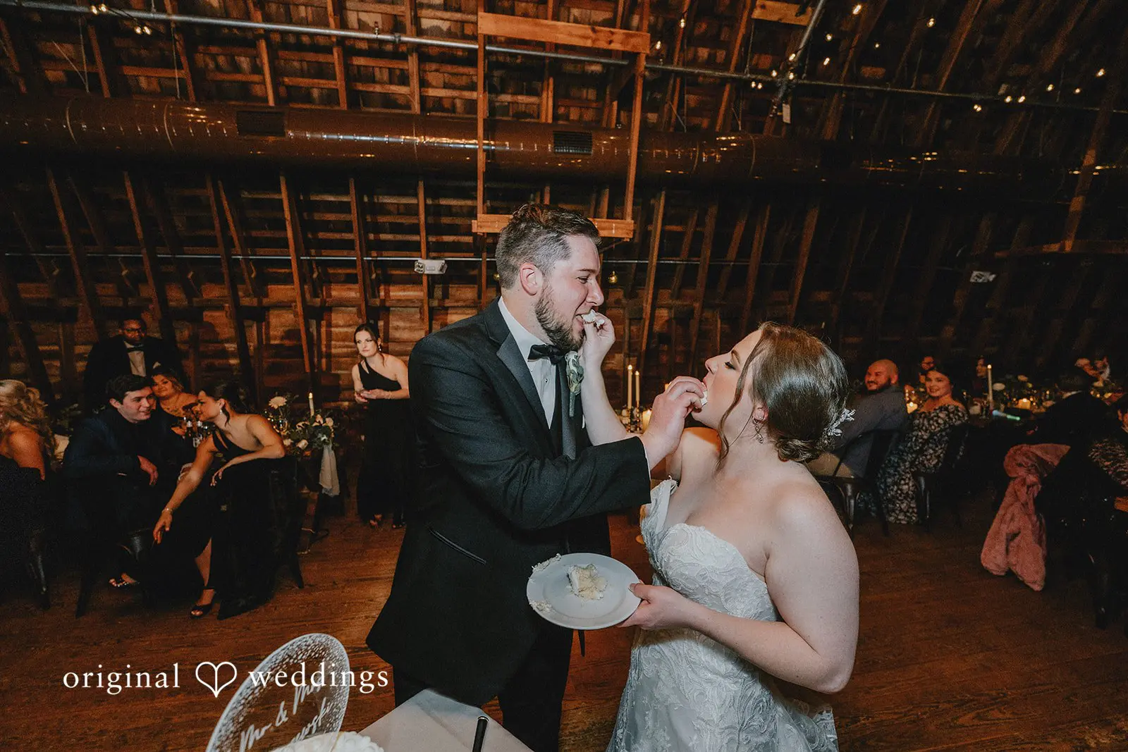 Stephanie + Zachary The bride and groom feed themselves cake at their wedding reception