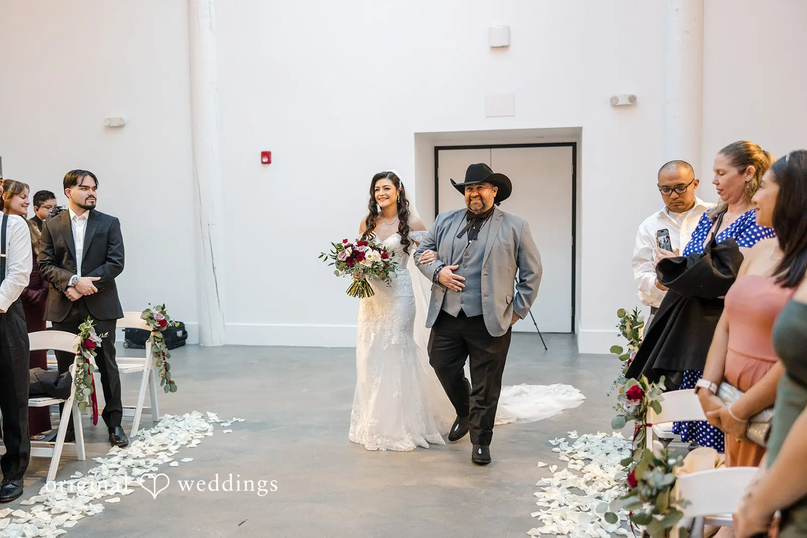 The bride's father escorts the bride down the aisle
