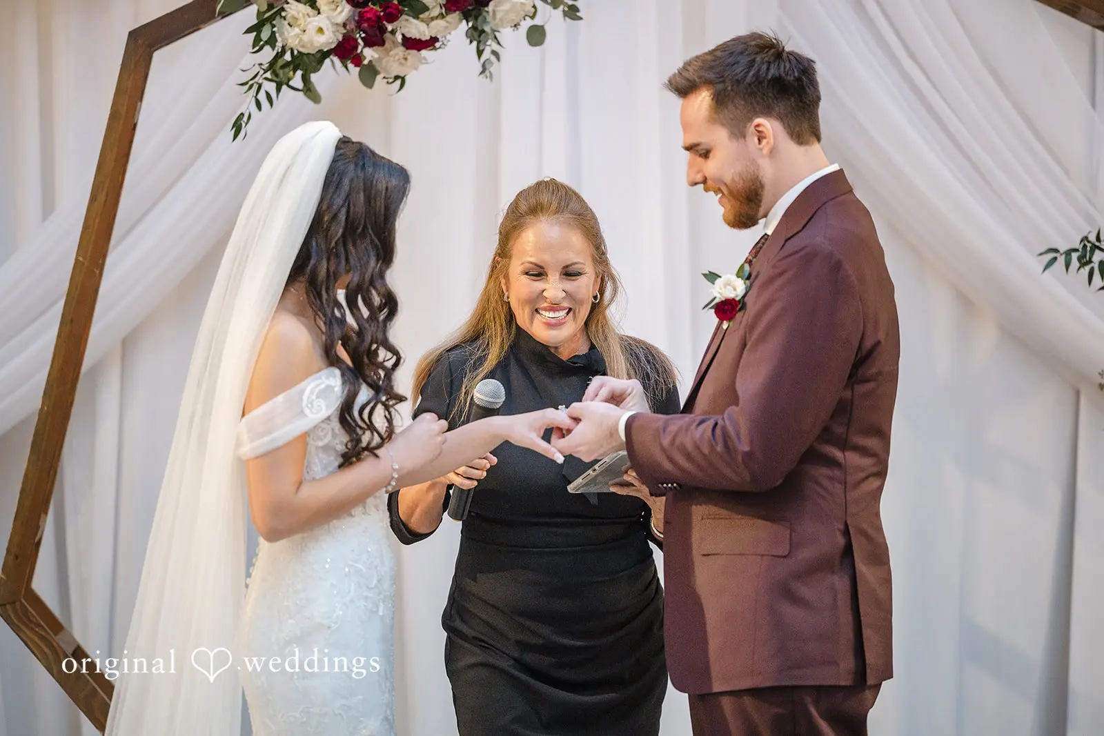 The groom puts a ring on the bride's finger