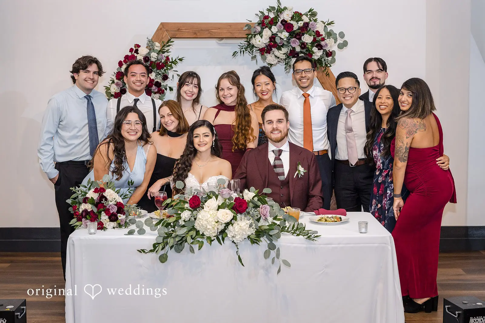 A portrait of the couple with their wedding party at the reception