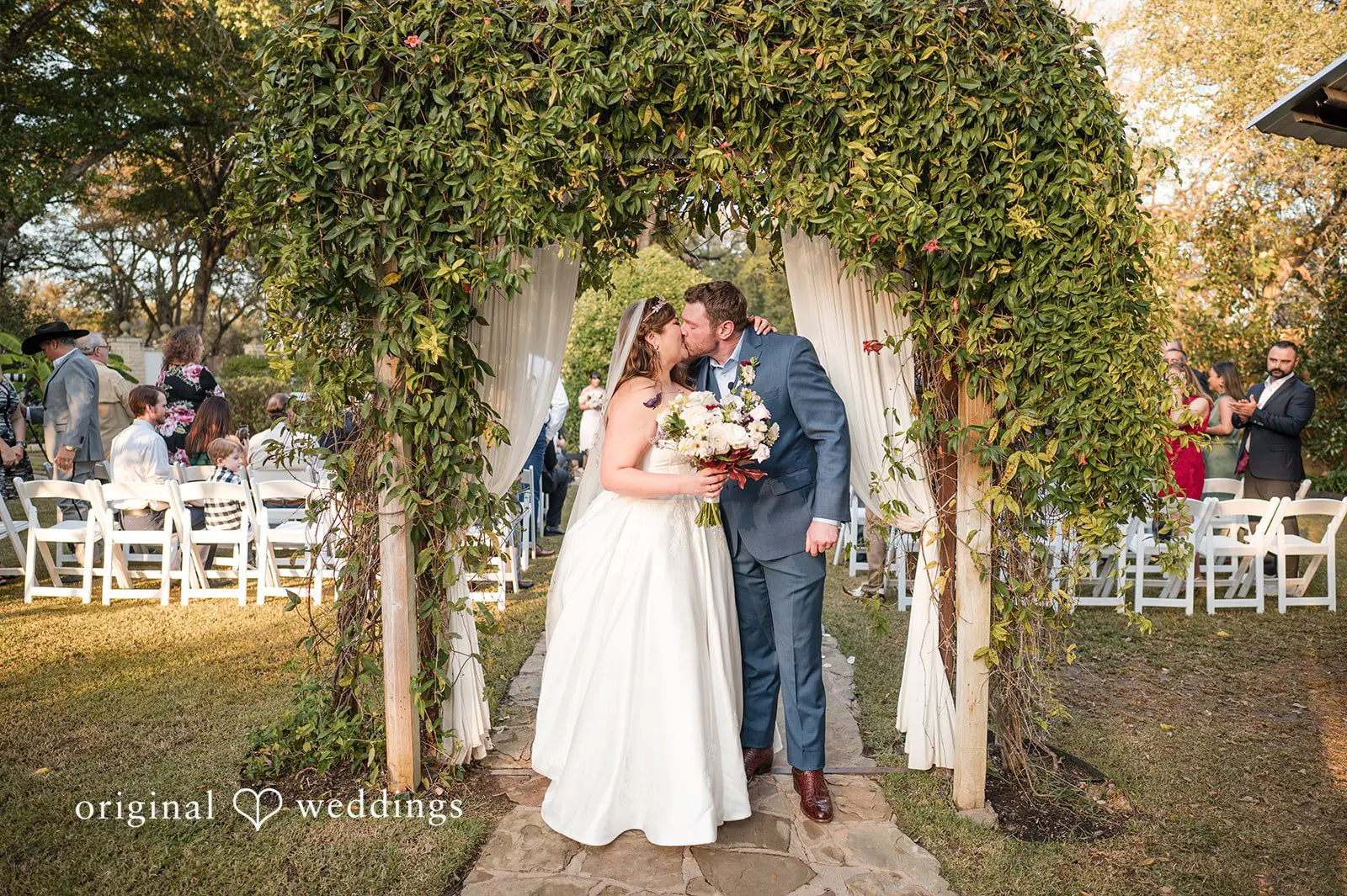 Ashley + David The bride and groom share a kiss after their wedding ceremony