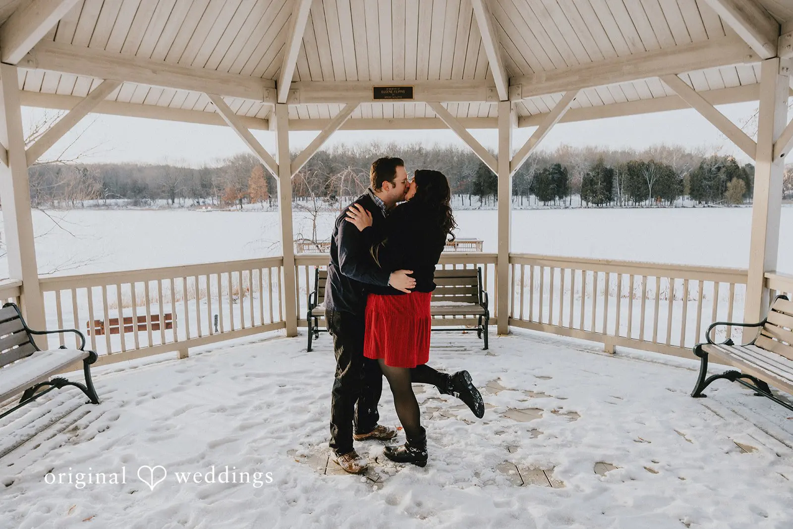 The couple shares a kiss in the snowy outdoor area