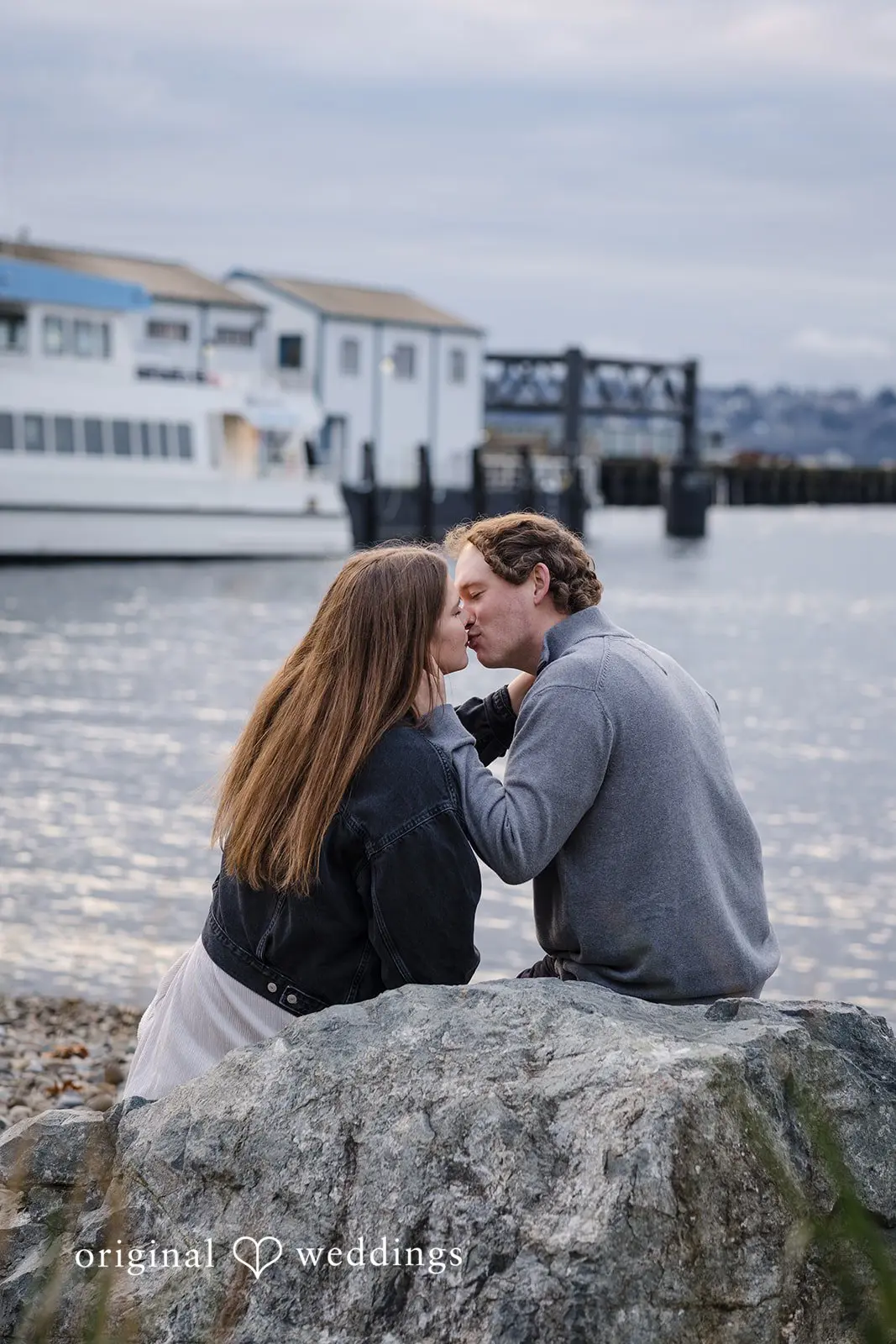The couple shares a kiss at the waterfront