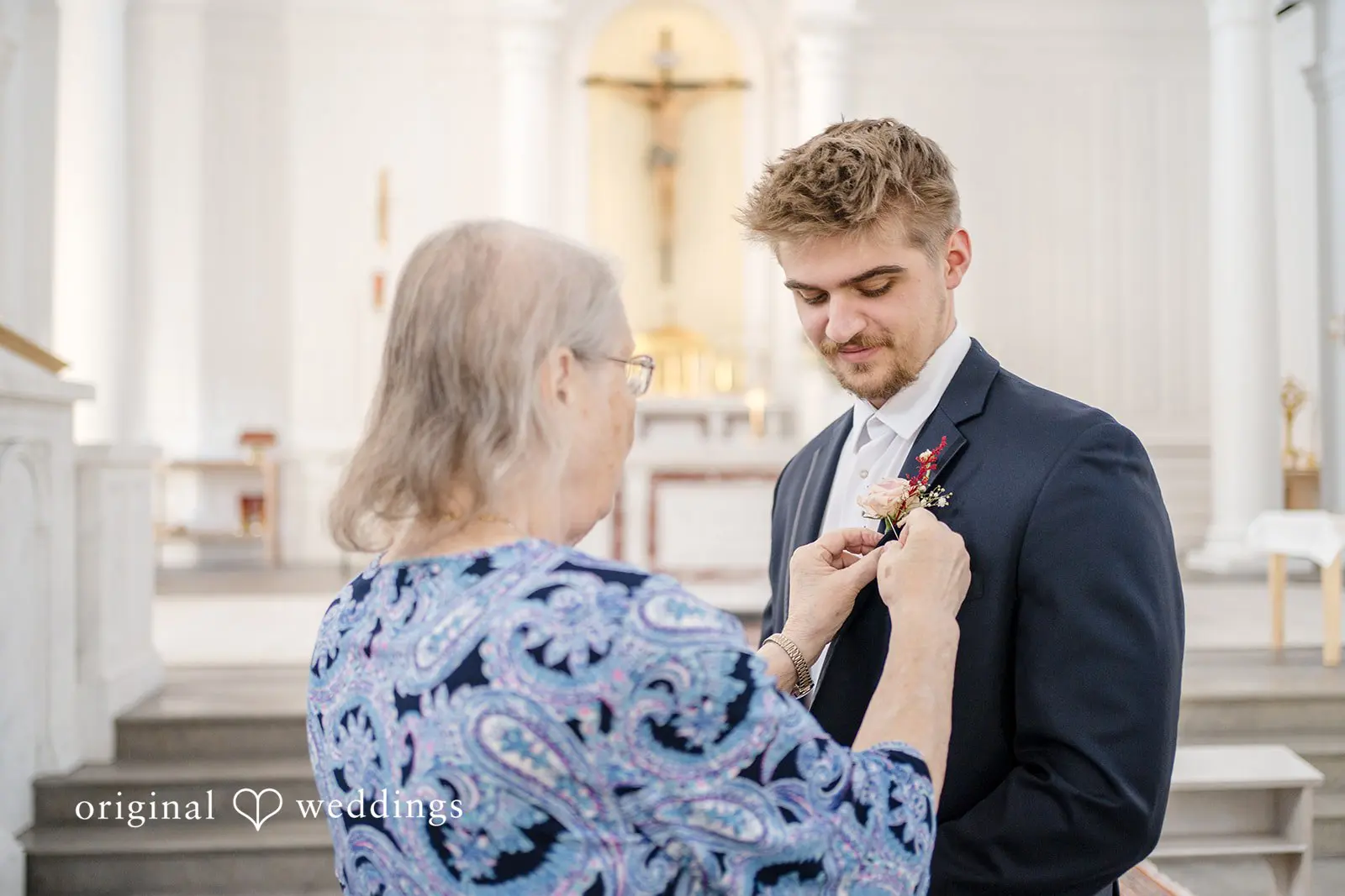Groom's mother getting him ready before the wedding ceremony