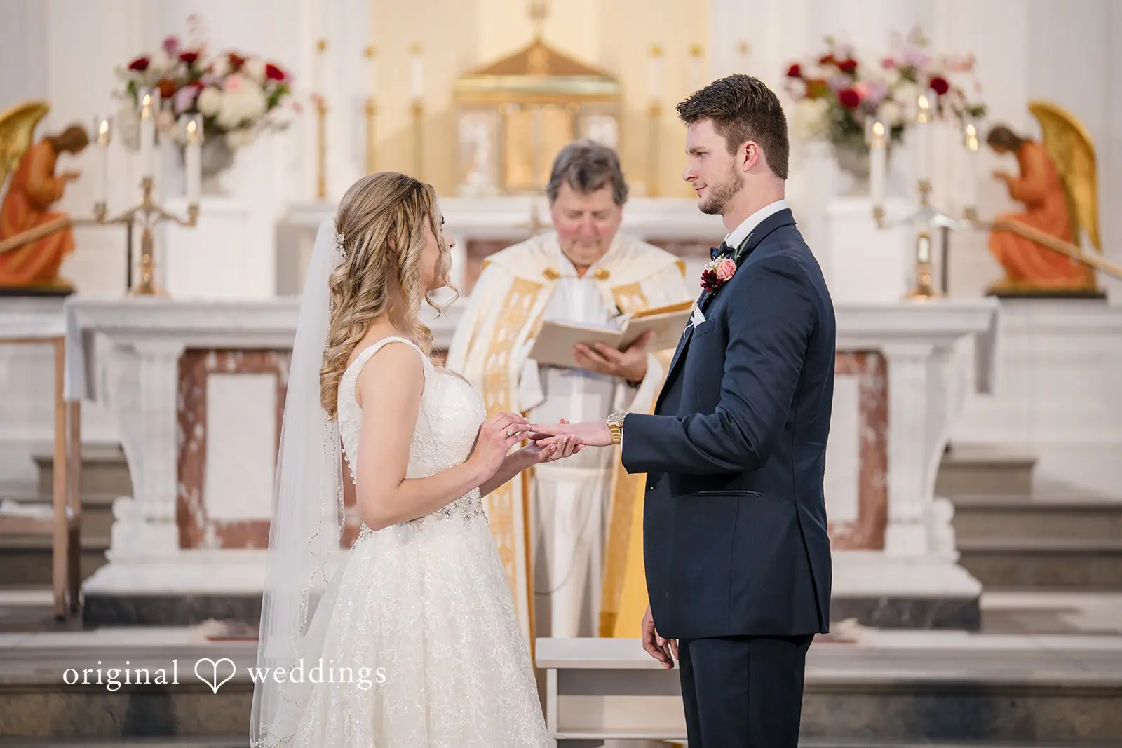 The bride puts a ring on the groom's finger
