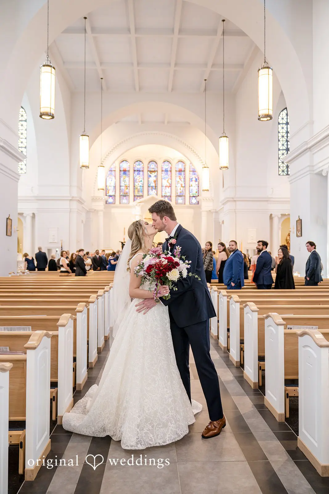 The Bride and groom kiss while exiting the hall