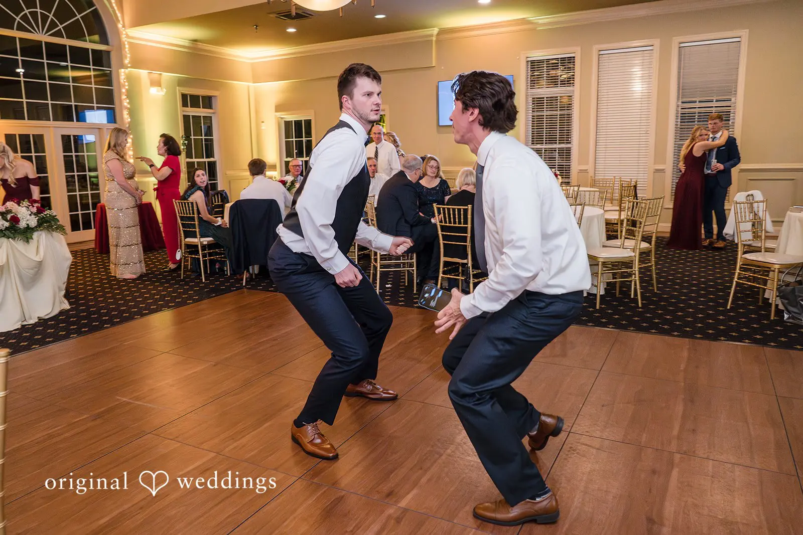 The groom dancing joyfully with one of the guests at the wedding reception