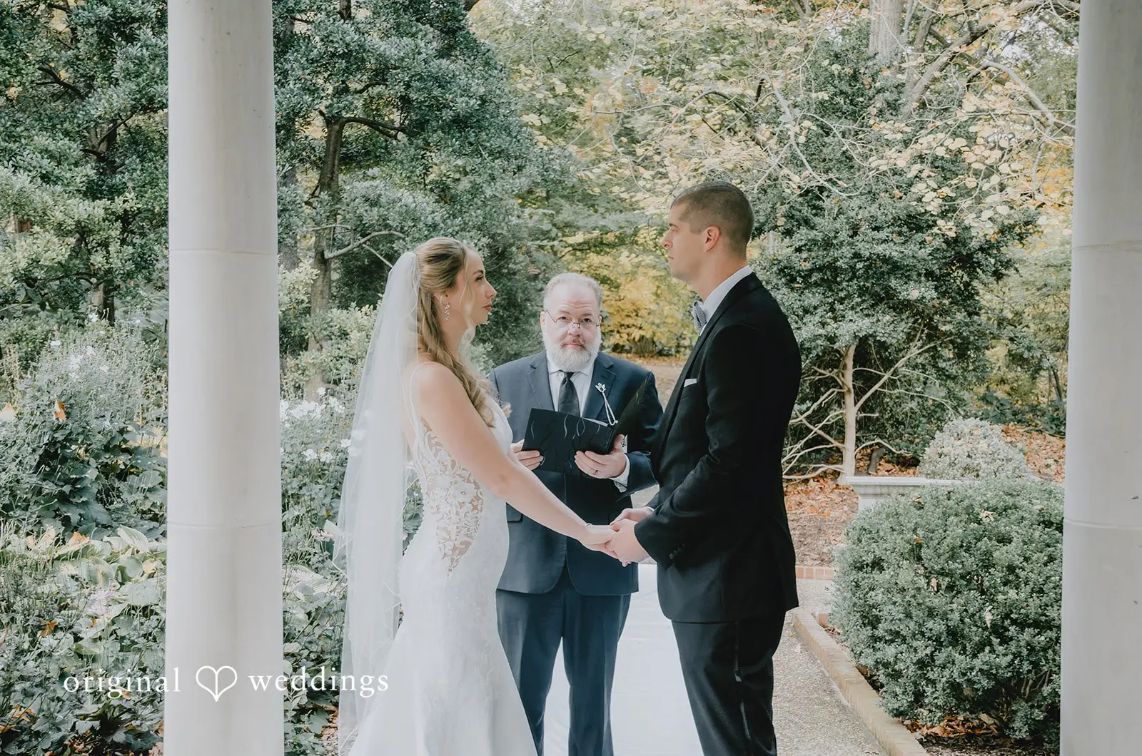 The bride and groom are exchanging marital vows at St. Louis Botanical Gardens