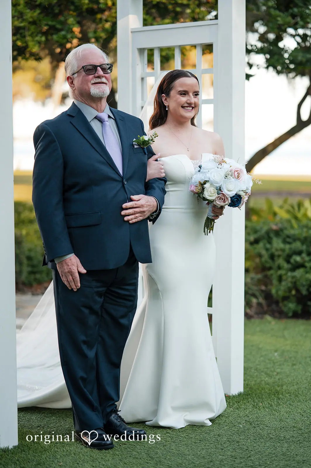 Bride walking down the garden aisle with her father during the outdoor wedding ceremony at Tampa Garden Club