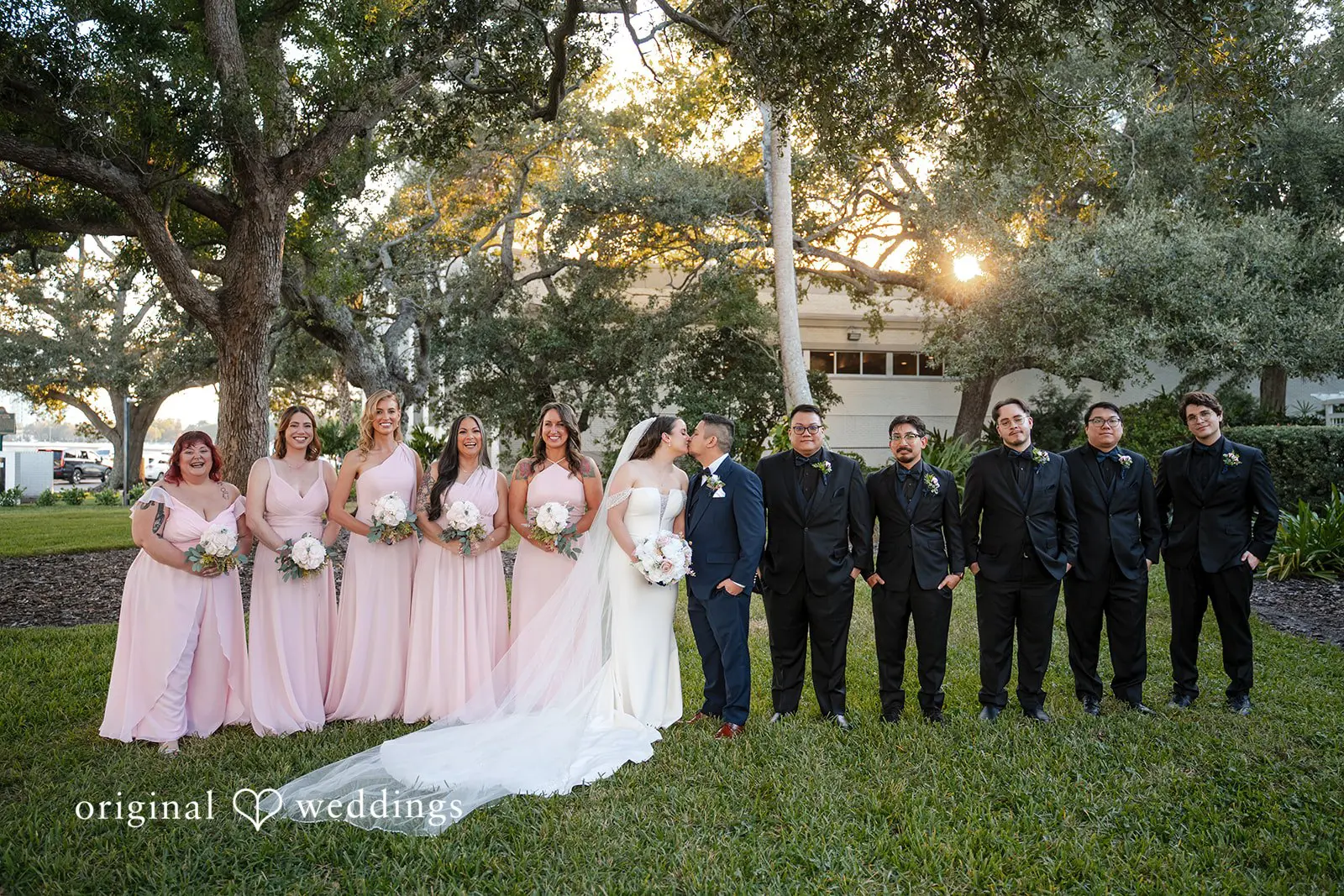 Wedding party with bridesmaids and groomsmen posing together outdoors
