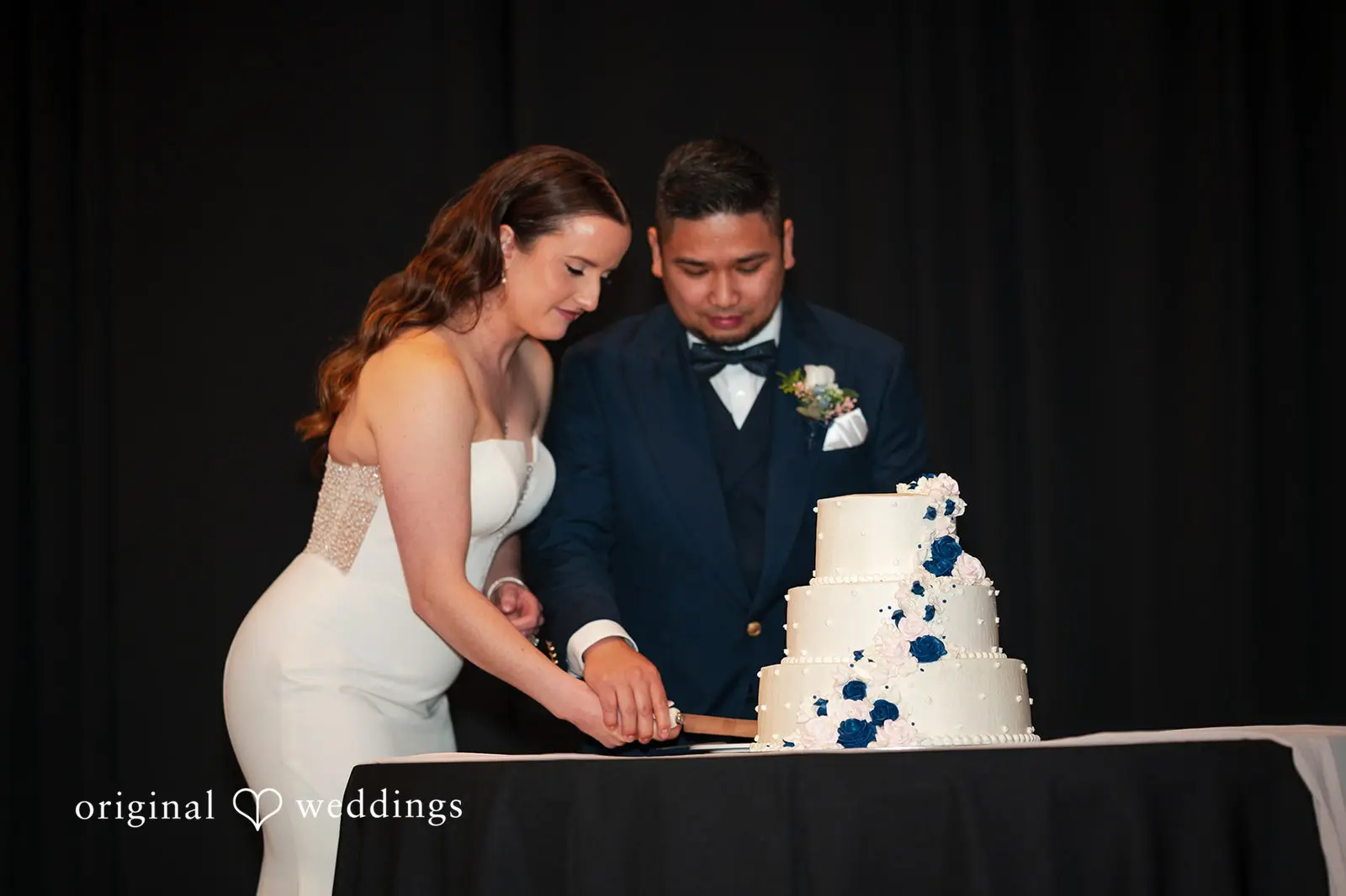Bride and groom cutting wedding cake at reception