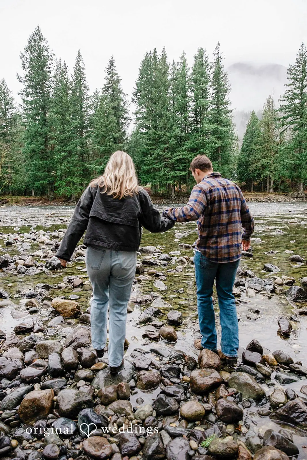 Our Seattle wedding photographer took a shot of the couple walking on the rocks by the riverbank