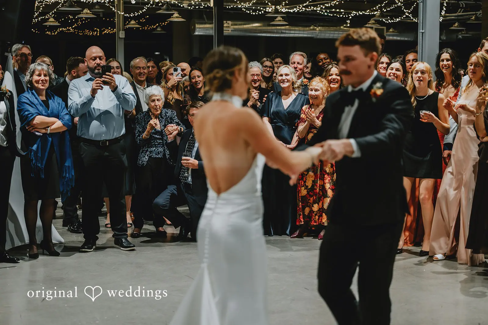The bride and groom are having their first dance at the reception