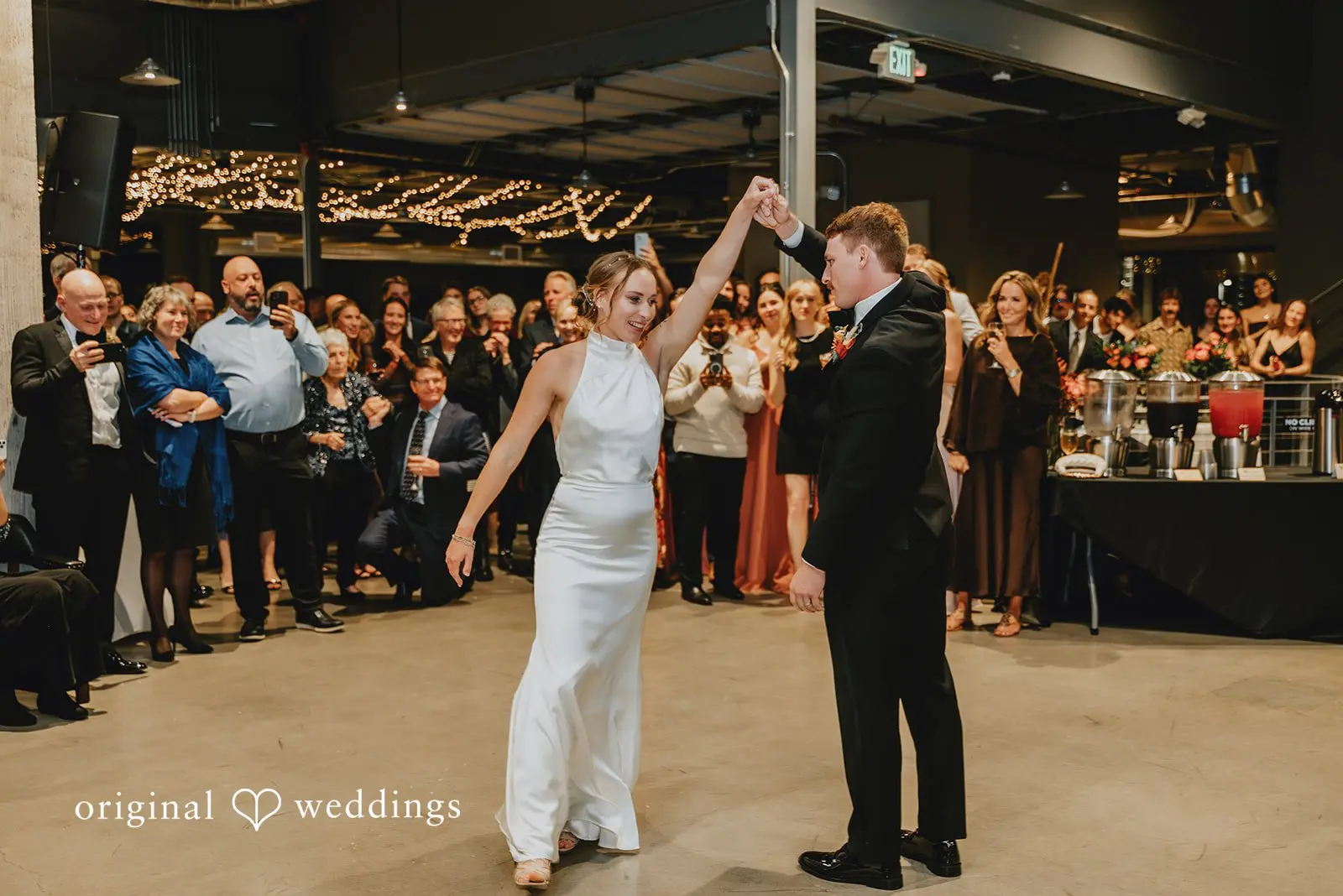 Guests cheering the couple as they dance
