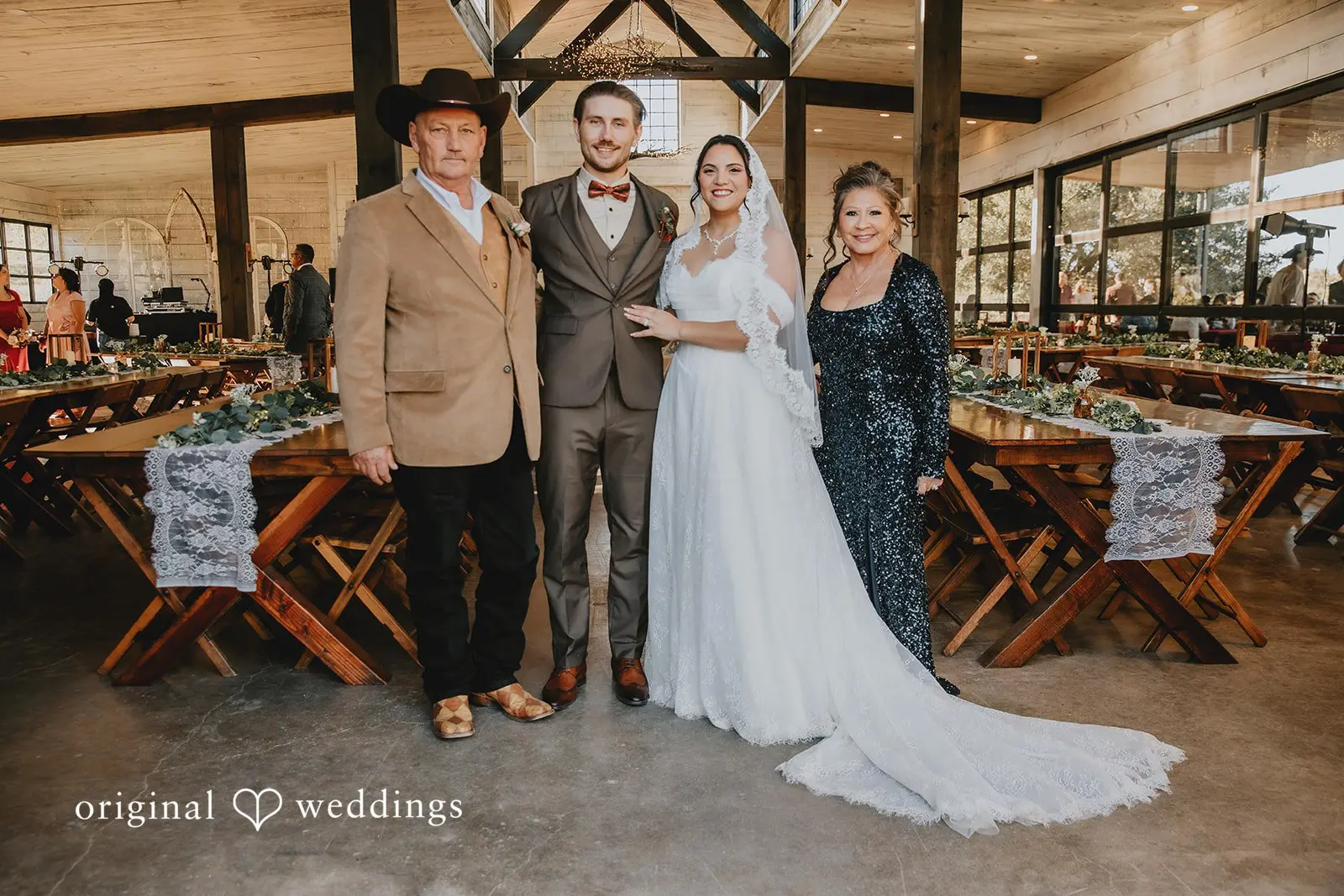 A portrait of the couple with their parents at the Two Wishes Ranch wedding reception