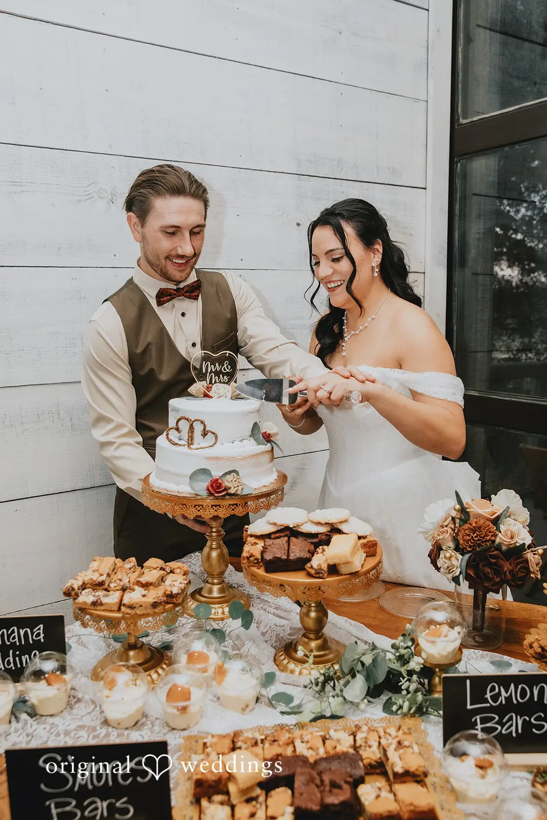 The bride and groom joyfully cut their cake at their wedding reception