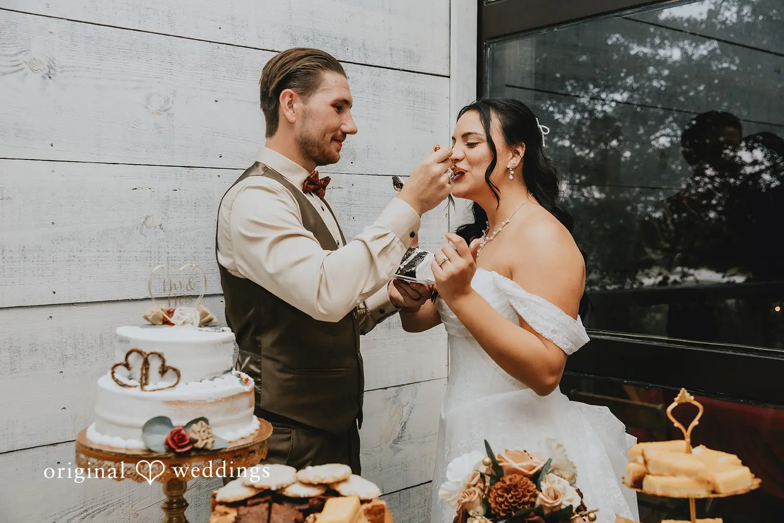 The groom feeds the bride their wedding cake