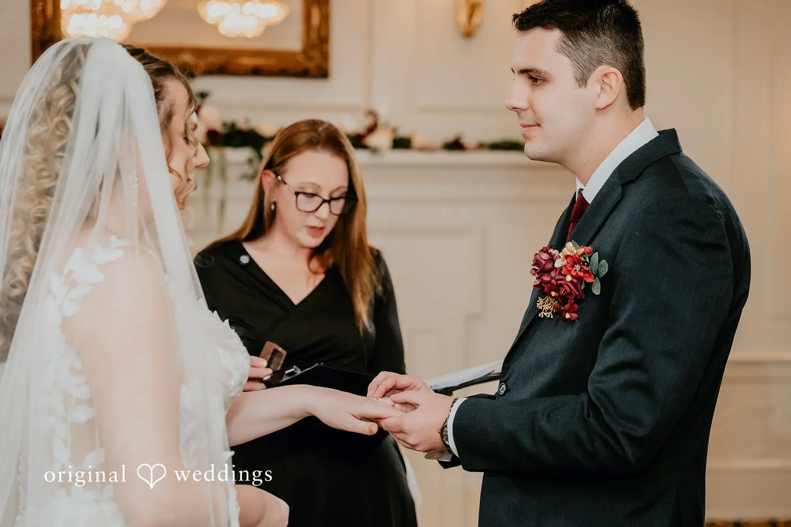 The groom puts a ring on the bride's finger