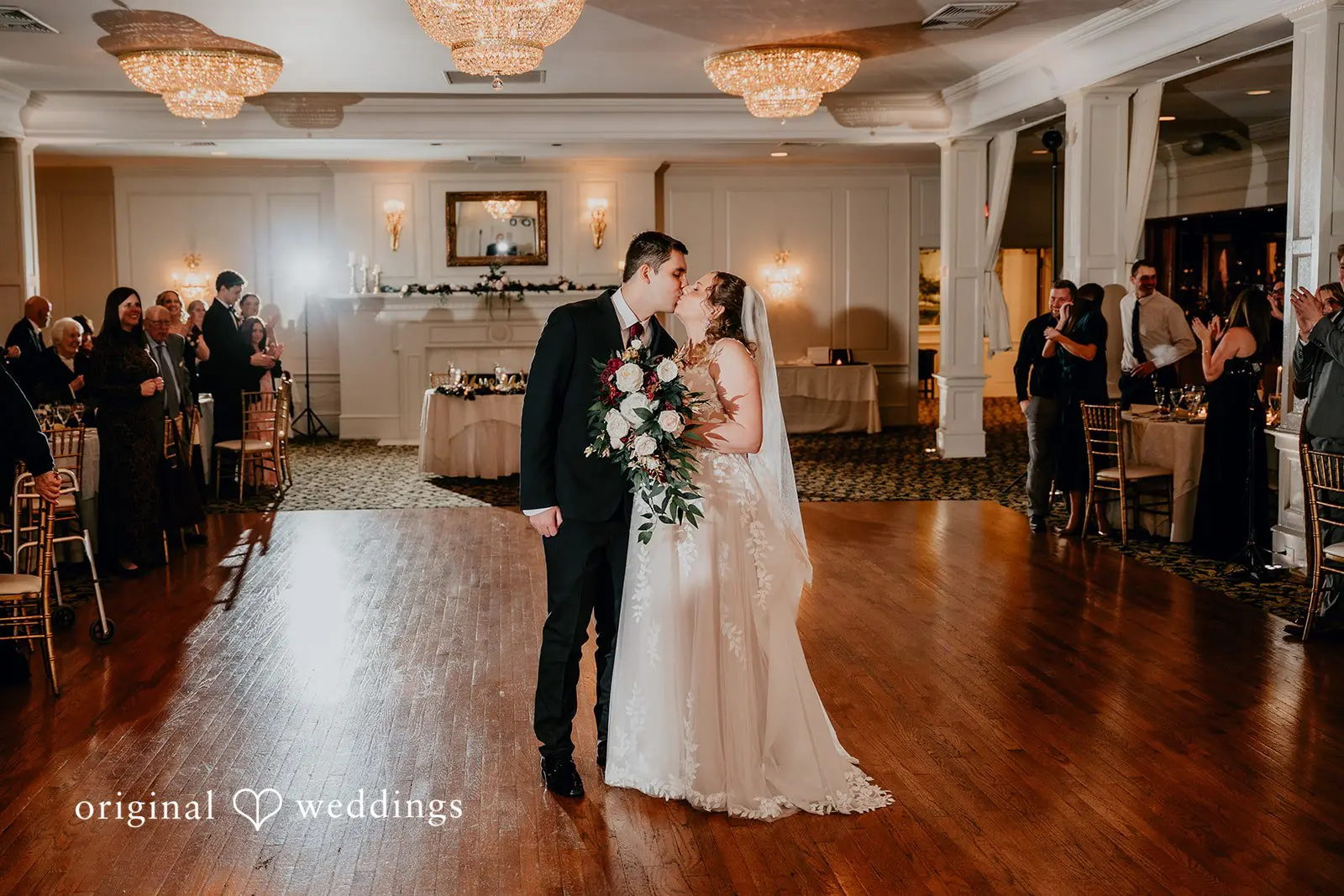 The couple shares a kiss at their wedding reception