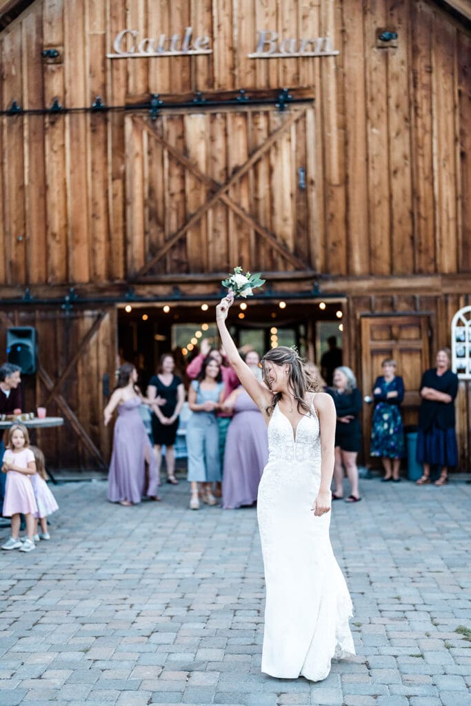 Bride throwing her flower at a Cattle Barn Wedding