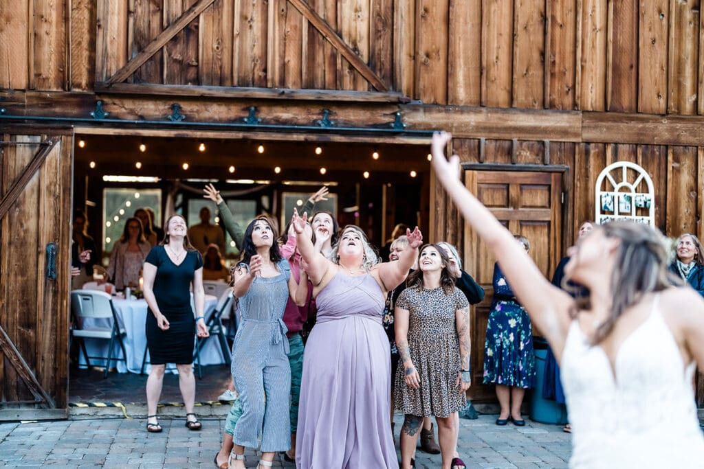 Bride throwing her flower at a Cattle Barn Wedding