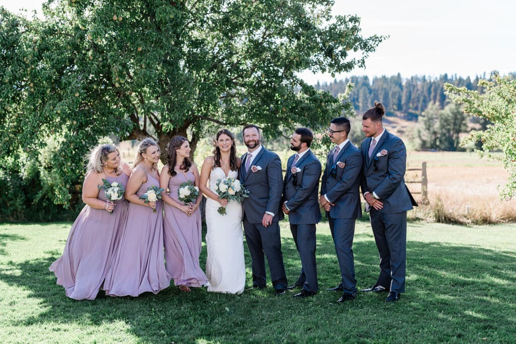 Couple and bridal train at a Cattle Barn Wedding