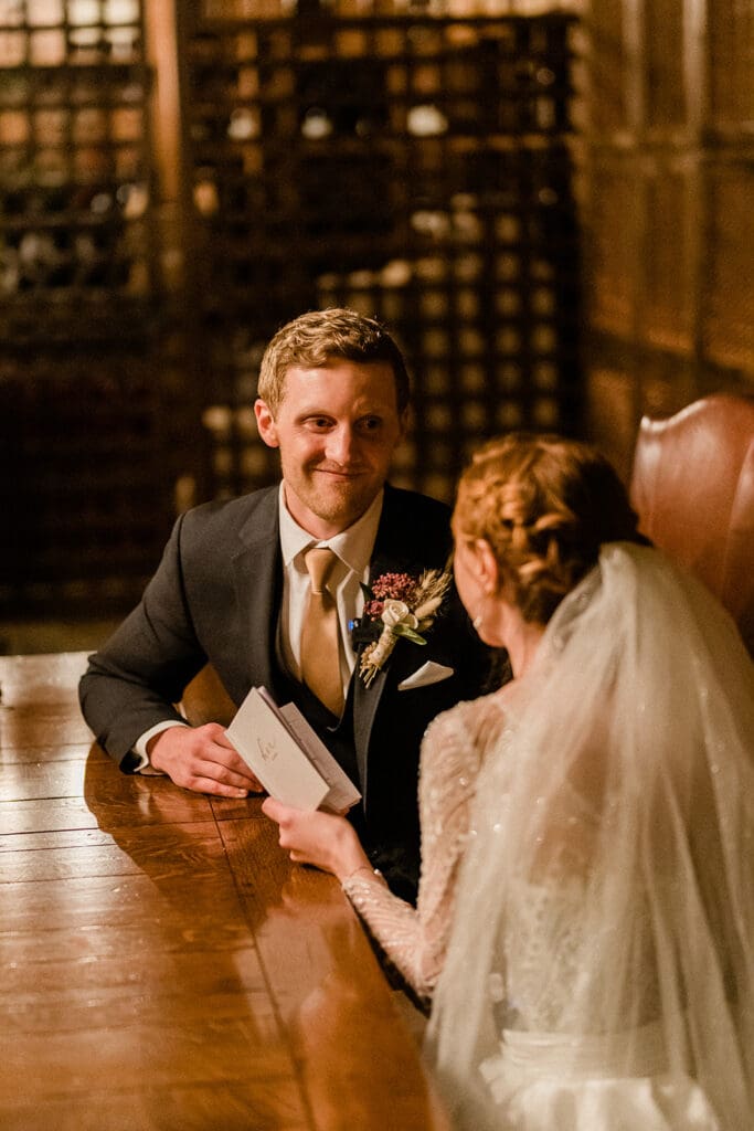 Bride and groom pose smiling at the camera inside Swiftwater Cellars
