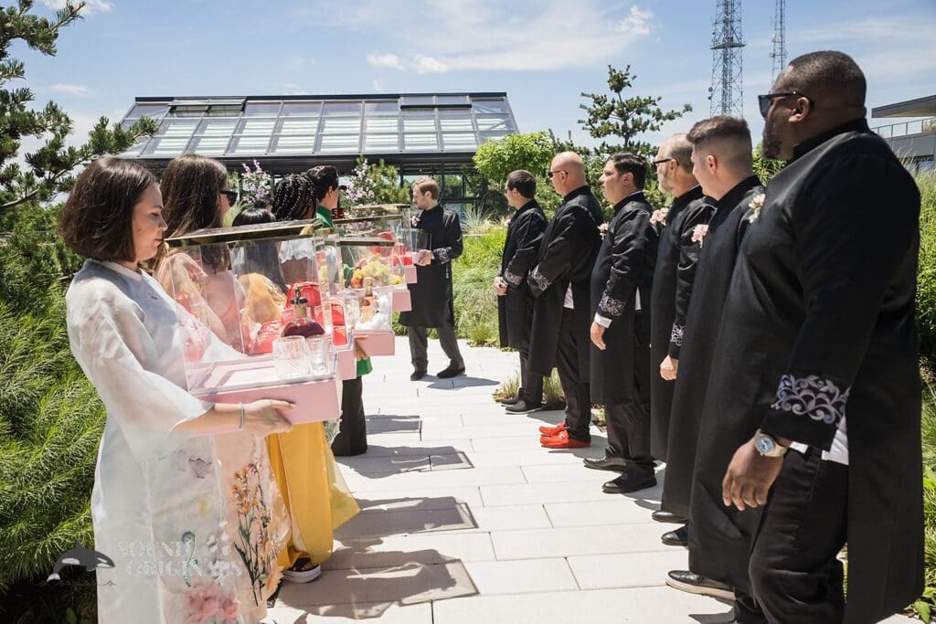 Photographer captures groom's men and bridal train with wedding gifts at the Private Home Wedding