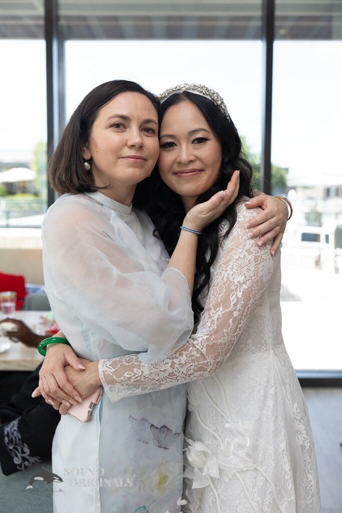 Pretty bride and friend take a beautiful shot at the Private Home Wedding
