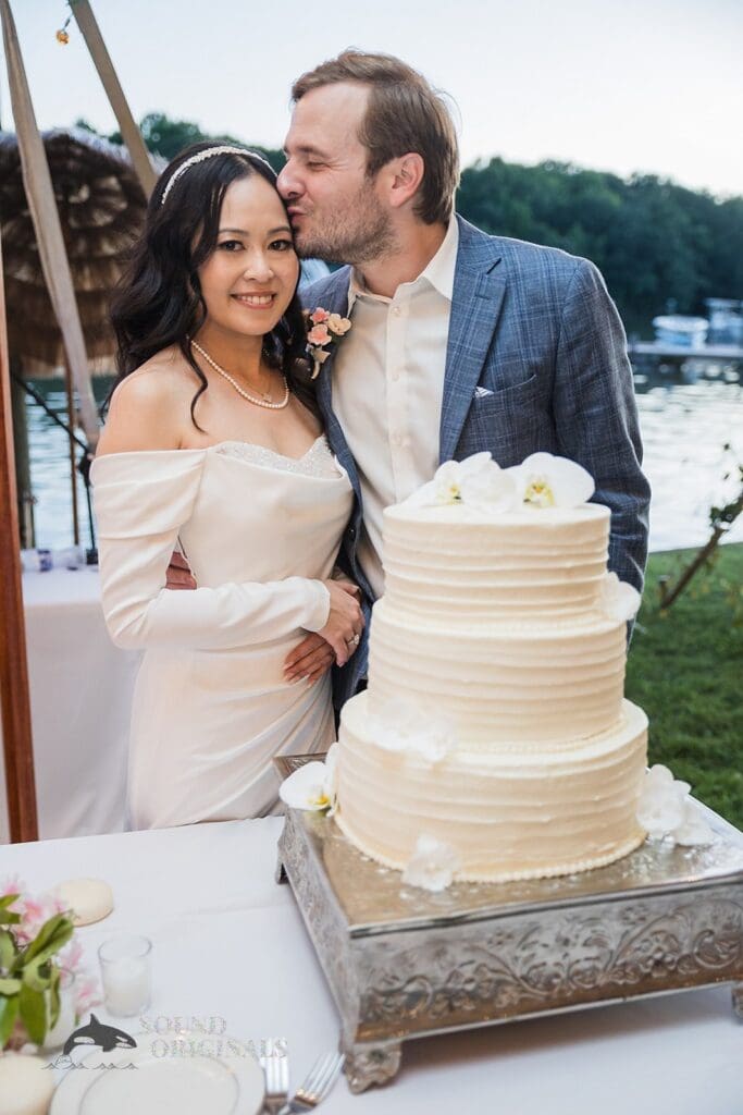 Husband adores beautiful wife as they get set to cut the wedding cake in the Private Home reception venue