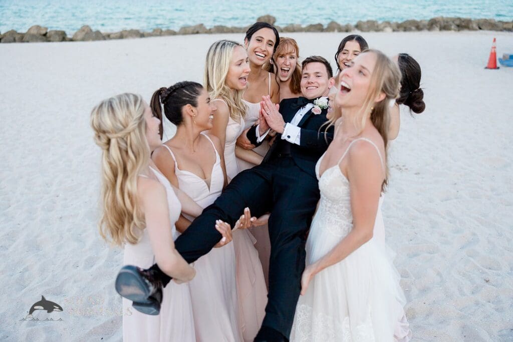 The groom being lifted by the bride and bridesmaids at The Palms Hotel & Spa Wedding