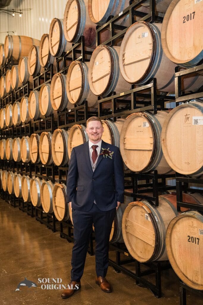 Handsome groom with big wine barrels at the background at Folino Estate Winery