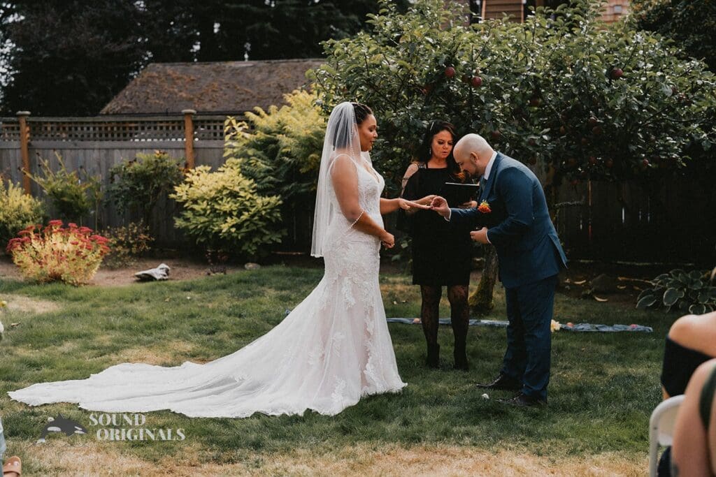 Kiara + Paul Groom puts the diamond ring on bride's finger at The Carey Gardens Wedding