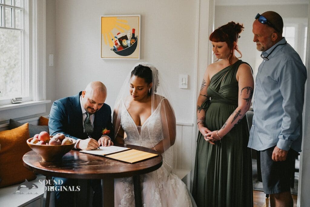 Kiara + Paul Husband and wife sign a marriage certificate at The Carey Gardens