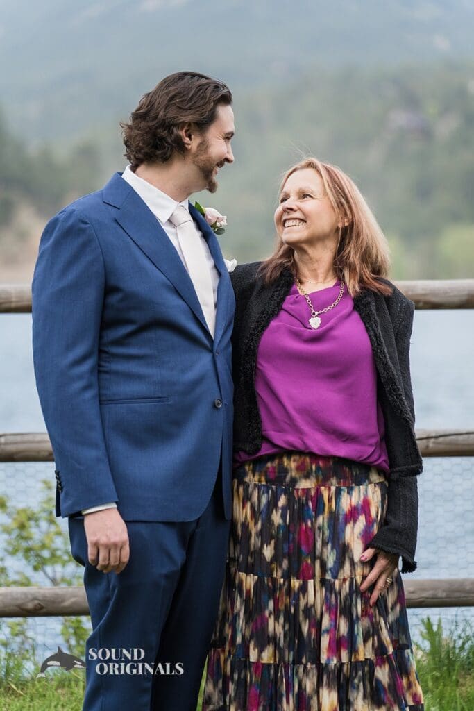 Happy Evergreen Lake House Wedding groom with Mum beside the venue's lake