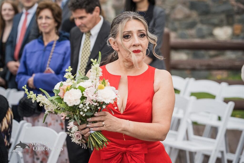 Photographer captures moment bride's mum holds the wedding flowers in Evergreen Lake House Wedding