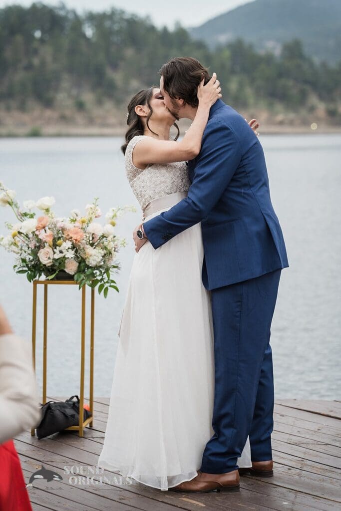 Evergreen Lake House Wedding bride and groom wrap their marital vows with a passionate kiss