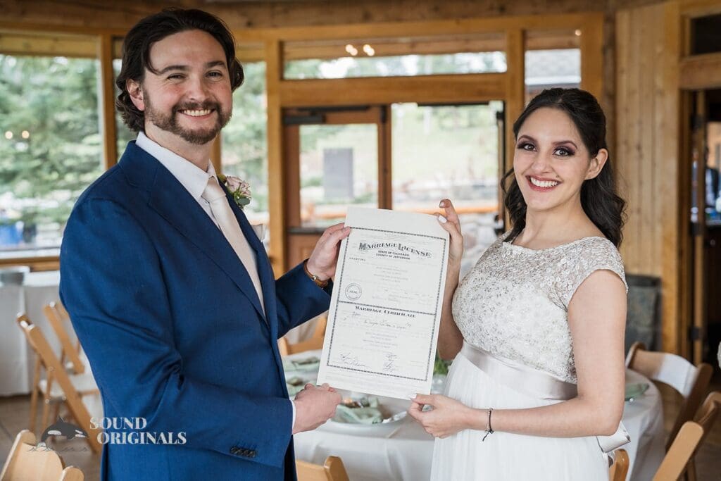 Evergreen Lake House Wedding couple show off their marriage certificate