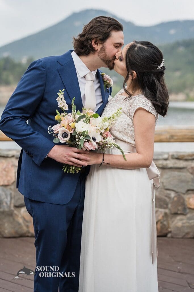 Evergreen Lake House Wedding bride and groom takes a romantic kiss beside the venue's lake