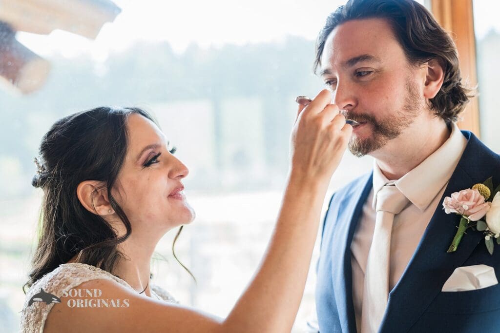 Bride feeds groom with yummy cake in Evergreen Lake House Wedding