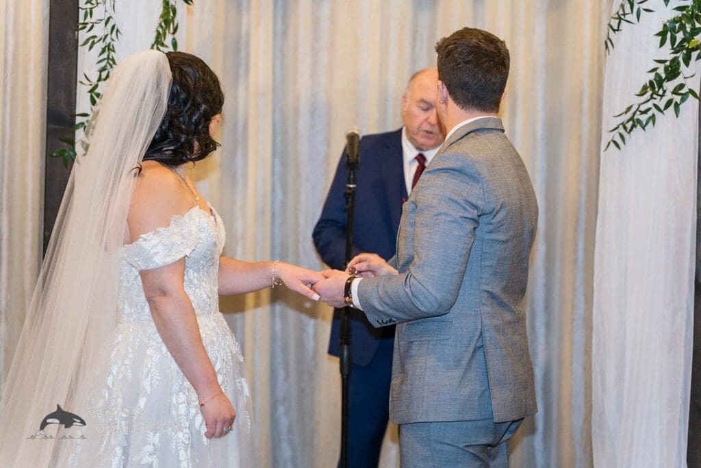 Groom ready to put a ring on the bride's finger at the Historic 1625 Tacoma Place Wedding altar