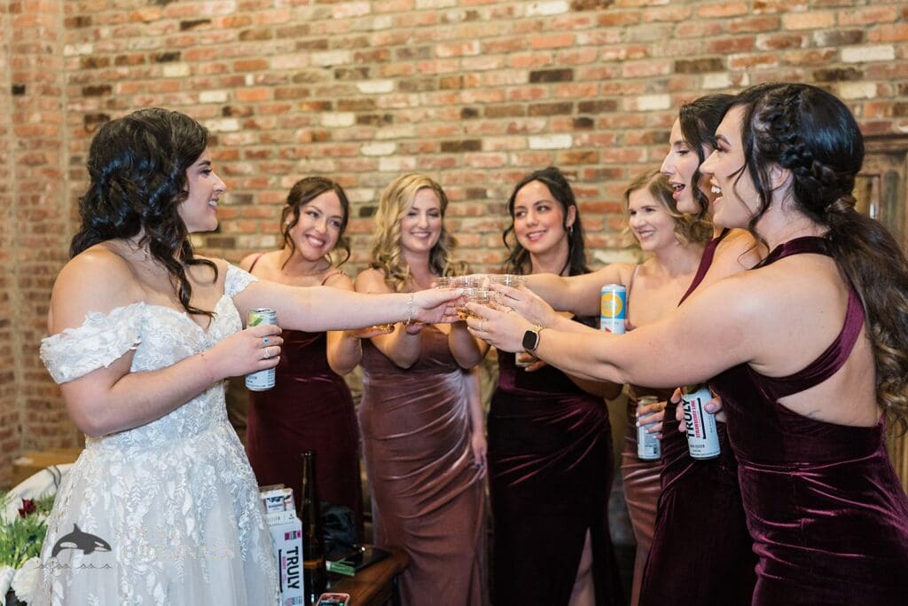 Bride showing off her wedding ring to bridal train in the Historic 1625 Tacoma Place Wedding