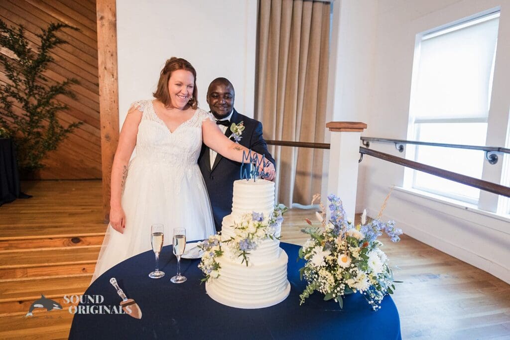 Radiant bride and groom ready to cut the wedding cake in The Cliff House Dallas Wedding reception