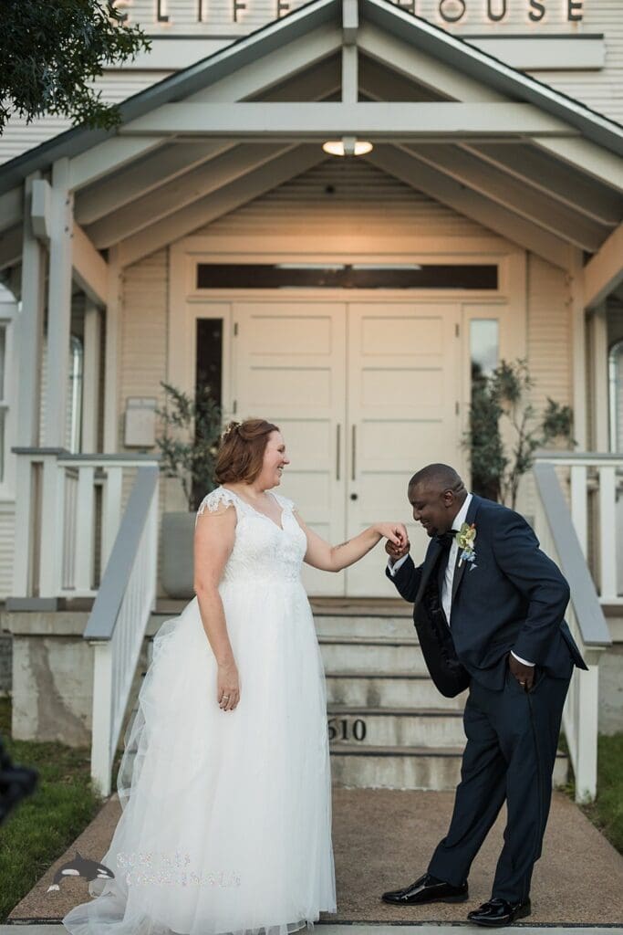 Husband and wife take a romantic shot in front of the beautiful Cliff House