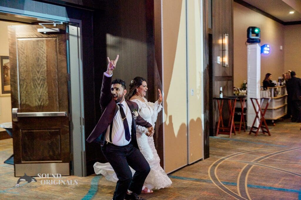 The bride and groom making an entrance to their Embassy Suites by Hilton Naperville Wedding