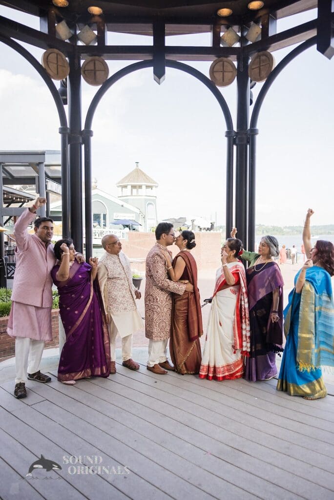 The bride and groom share a kiss while guests look on at their Torpedo Factory Art Center Wedding